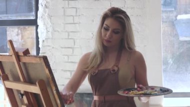 Stüdyosunda, çalışan kadın sanatçı boya tuval üzeri yağlıboya