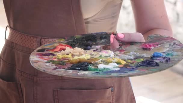 Paleta con diferentes colores de pintura al óleo en artista de la mano — Vídeo de stock