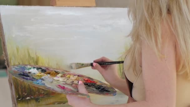 Женщина, создающая картины масляными красками и кистью, замедленная съемка — стоковое видео