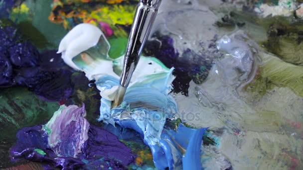 Mezcla de pinturas al óleo con pincel en paleta. cámara lenta, primer plano — Vídeo de stock