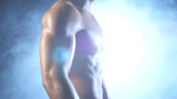 Gewichtheber oder Bodybuilder demonstriert seinen Körper, seine Kraft und Ausdauer. schwarzer Rauch Hintergrund — Stockvideo