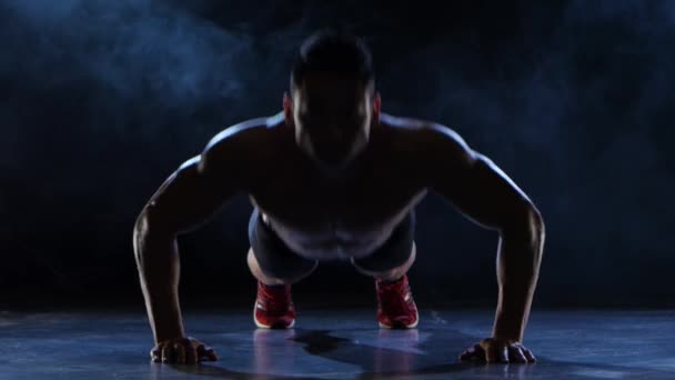 Asiatische muskulöse Mann Liegestütze. schwarzer Rauchhintergrund. Silhouette — Stockvideo