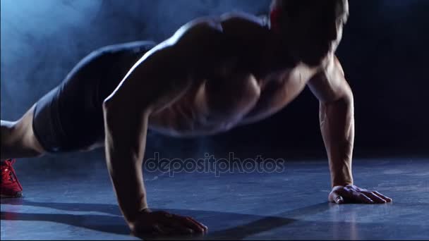 Gewichtheffer is uit te oefenen, zijn handen schudden van de vloer. Zwarte rook achtergrond. Silhouet — Stockvideo