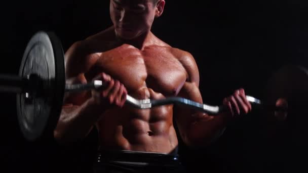 Aziatische bodybuilder opleiding biceps in de sportschool. Zwarte achtergrond — Stockvideo