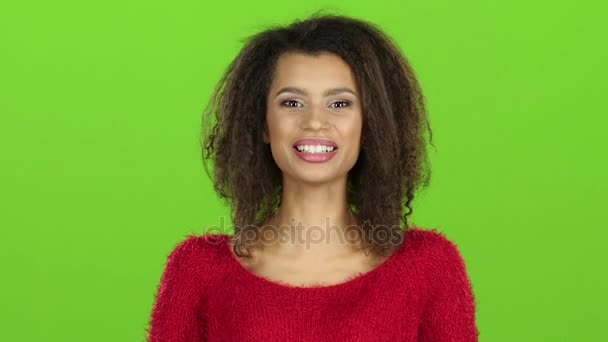 Афро-американка заразительно смеется на зеленом экране. Медленное движение — стоковое видео