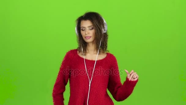 女性を性的緑色の画面でヘッドフォンで踊る。スローモーション — ストック動画