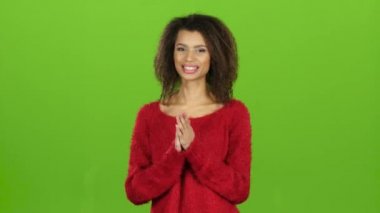 Afro Amerikalı kadın gülümsüyor ve alkışlar onu eller, yeşil ekran