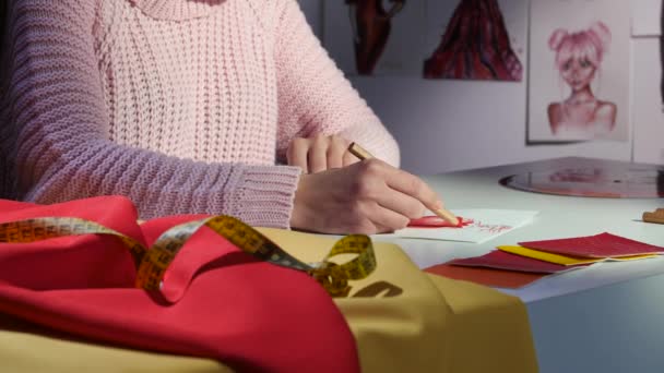 Le mani di designer disegnano uno schizzo di un bel vestito rosso. Da vicino. — Video Stock