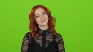 Kız görünüyor etrafında ve sevimli gülümseme. Yeşil ekran. Yakın çekim. Ağır çekim