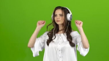 Esmer kulaklık ile enerjik müzik dinler ve palyaçoluk oluşturur. Yeşil ekran