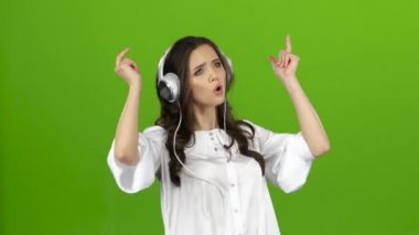 Esmer kulaklık ile enerjik müzik dinler ve palyaçoluk oluşturur. Yeşil ekran