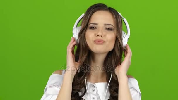 Красивая девушка с длинными волосами слушает музыку через