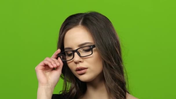 Chica en gafas comienza a coquetear y sexualmente quitar gafas. Pantalla verde. De cerca. — Vídeo de stock