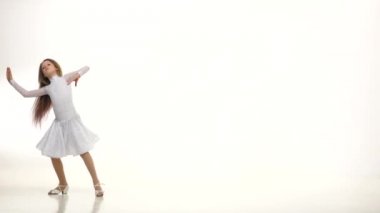Çocuk dansları parke zemin üzerinde güzel bir beyaz elbiseli. Beyaz arka plan. Yavaş monion