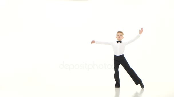 Kleine jongen de danseres draait uit sierlijk de bewegingen. Witte achtergrond — Stockvideo