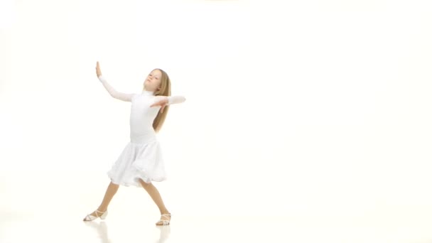 L'enfant danse dans une belle robe blanche sur un parquet. Fond blanc — Video