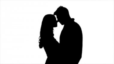 Sevgi dolu çift birbirinize bakın ve öpmeye başlar. Siluet. Beyaz arka plan. Ağır çekim