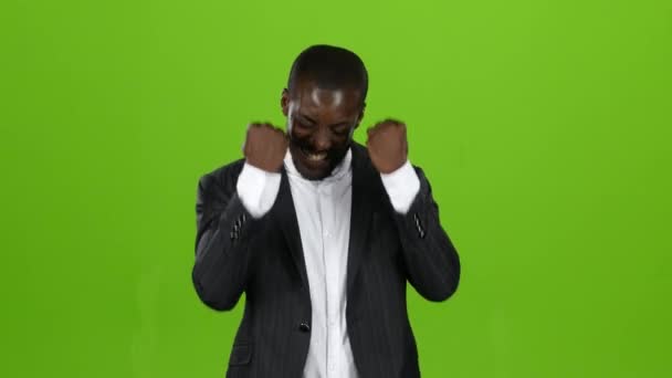 Chlap v přísné černý oblek je šťastný s jeho vítězství. Zelená obrazovka — Stock video