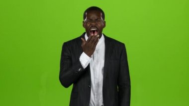 Afro-Amerikan, çok yorgun ve uyumak istiyor, o esner. Yeşil ekran