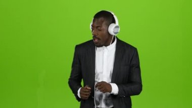 İşadamı ve kulaklık müzik ve oracıkta dans kulakları üzerinde. Yeşil ekran