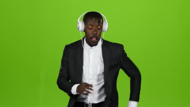 Američan Afričana muž tance pohybu Latinské a poslouchá hudbu v sluchátka. Zelená obrazovka — Stock video