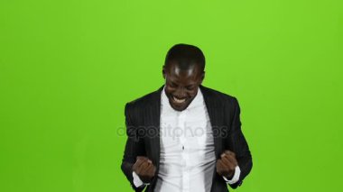 Afrika kökenli Amerikalı sıkı siyah elbiseli zaferi ile mutlu. Yeşil ekran. Ağır çekim