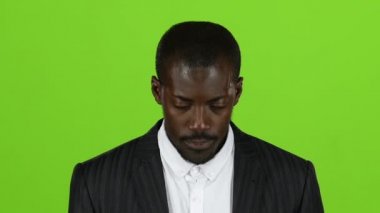 Afrikalı-Amerikalı bakışlarını yükseltir ve görünüyor. Yeşil ekran. Ağır çekim