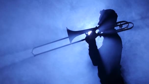 Homem trompetista em destaque no estúdio esfumaçado toca trombone — Vídeo de Stock