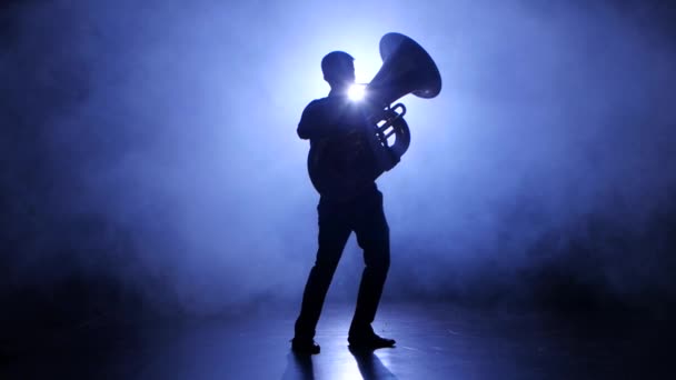 Trompeter-Mann im Rampenlicht im verrauchten Studio spielt auf Tuba — Stockvideo