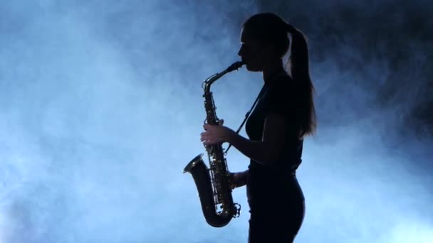 Silueta músico profesional femenino tocando en saxofón. Estudio ahumado aislado — Vídeo de stock