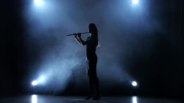 Zenész női fúvós hangszer klasszikus dallamot játszik. Füstös stúdió — Stock videók