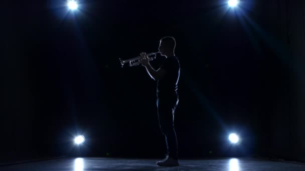 Musicista in studio buio con riflettori che suona tromba slow jazz — Video Stock