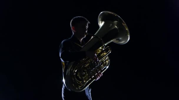 Homem toca na tuba melodia lenta no estúdio preto — Vídeo de Stock