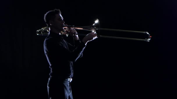 Trompettist speelt op de snelle melodie blaasinstrument in zwarte studio — Stockvideo