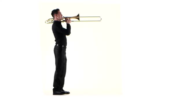 Trumpeter plays on wind instrument fast melody in white studio — Stock Video