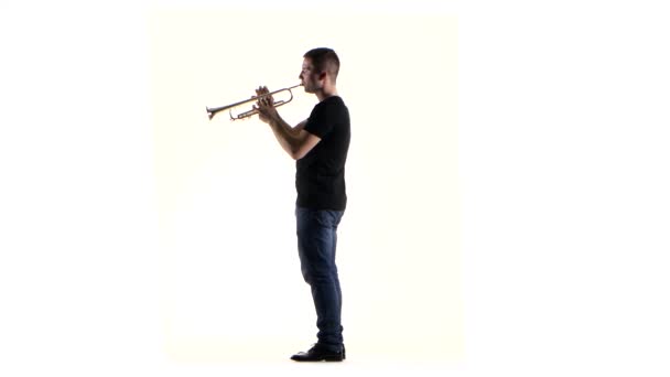 Man trompettist blaast het motief in blaasinstrument. Witte studio — Stockvideo
