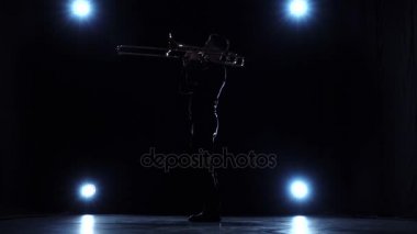 Konser, trombonunu oynarken müzisyen solo. Karanlık stüdyo, ağır çekim