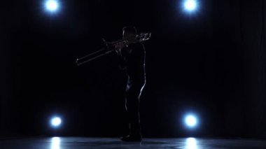 Trombon, solo konser oynamaya müzisyen. Karanlık stüdyo, ağır çekim