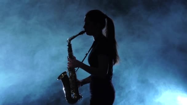 Силуэт музыкант женщина играет на саксофоне. Студия Смоки, замедленная съемка — стоковое видео