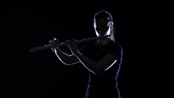 Female musician blows motif in flute in slow motion. Studio — Stock Video