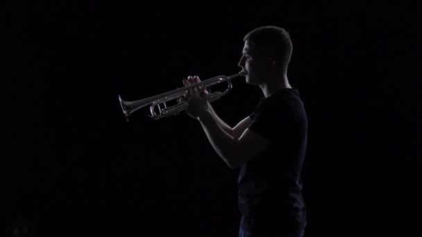 Trompettist man speelt melodie in slow motion. Zwarte studio achtergrond — Stockvideo