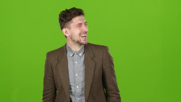 Businessman stands and smiles, a joke makes him laugh. Green screen — Stock Video