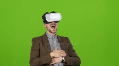 İşadamı sanal gözlüklü komik video gülüyor görünüyor. Yeşil ekran