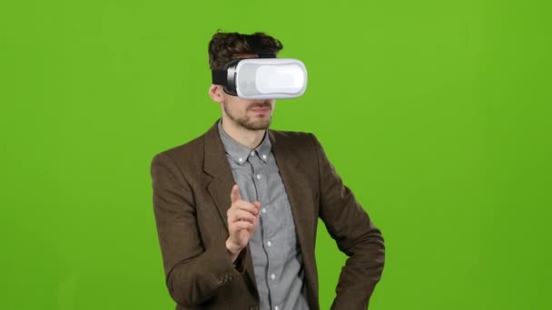 Boy in virtual glasses looks at imaginary photographs and smiles. Green screen — Stock Video