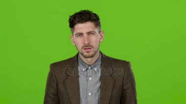 Çekici erkek işadamı elbiselerini ayarlar, yüzünü mendil, kendini hayran. Yeşil ekran. Ağır çekim