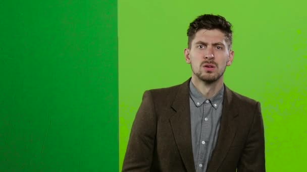 Mann schaut hinter einem grünen Brett hervor und schreit viel. Green Screen. Zeitlupe — Stockvideo