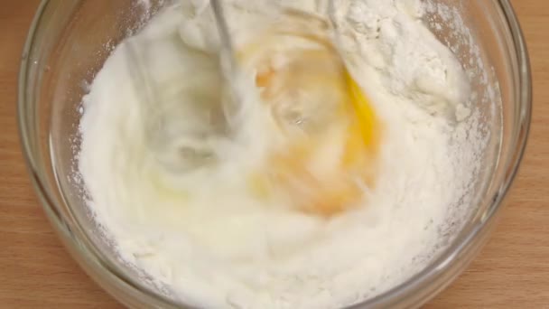 Ingrediënten voor omelet zweep mixer in glazen kom. Slow motion — Stockvideo