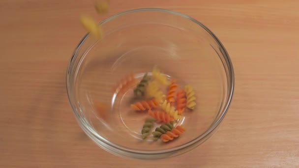 Gekleurde noedels zijn gegoten in de glasplaat in slow motion — Stockvideo