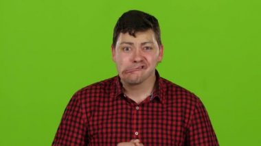 Adam gülümsüyor, onları farklı palyaçoluk ve dil gösteren. Yeşil ekran. Yakın çekim