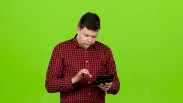 Man considers the profit on the calculator and he is bankrupt. Green screen — Stock Video